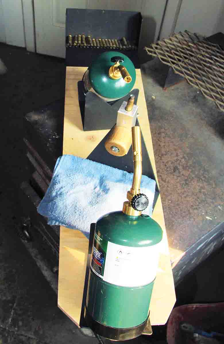 The complete Anneal-Rite system is shown, including the center “tower” with aluminum brass holder, opposing torch stands, torches and attached propane bottles and a case tray at the far end.